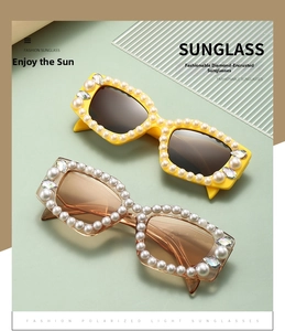 Détail de lunettes de soleil avec bordure en perles et strass sur fond vert clair
