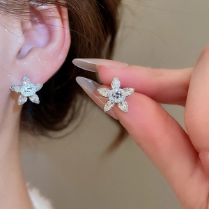 Detailed macro view of silver flower stud earrings with marquise-cut zircon stones