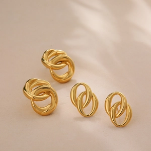 Detail of 18K gold double oval hoop and triple interlaced earrings with polished finish