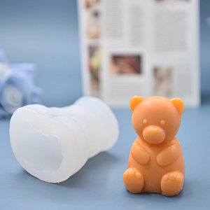 3D cute sitting bear silicone mold with finished orange candle on blue background