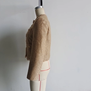 Detailaufnahme der Tweedjacke mit goldenem Lurex-Gewebe und eleganten Fransen