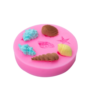 Pink silicone mold for starfish and seashell fondant decorations with ocean-themed results