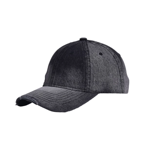 Macro shot of distressed black denim baseball cap with vintage washed fabric textures