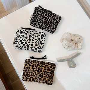 Detailed view of leopard print cotton pouches in three colors with woven brand labels