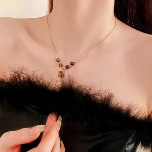 Elegant silver necklace with round brown tiger eye stone pendant on female neck
