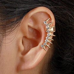 Close-up of a gold-plated rhinestone ear cuff with pearls on a model's ear