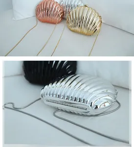 Detail view of shell-shaped acrylic evening clutches with metallic texture and metal chains