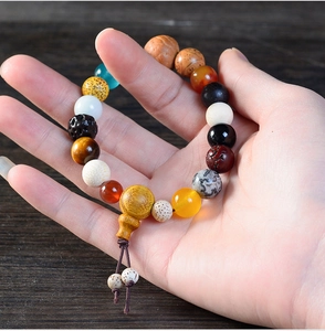 Detail of diverse 18-seed Buddhist prayer bracelet with multi-colored wood and stone beads
