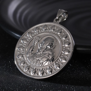 Macro shot of silver Saint Benedict cross pendant with religious relief on a dark plate