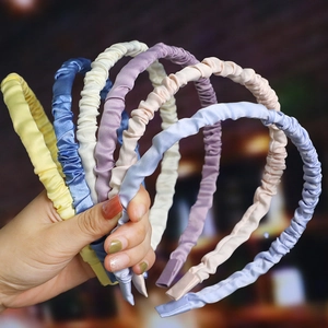 Detailed view of glossy wavy headbands in assorted pastel colors like blue and yellow