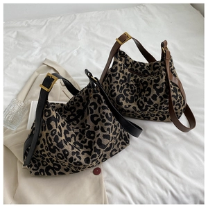Detail of leopard print canvas shoulder bag with premium leather straps on a beige blazer