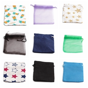 Variety of drawstring jewelry gift bags in assorted colors and patterns on white background