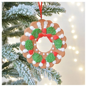 Detailed view of gingerbread style Christmas wreath ornament hanging on snowy tree branch