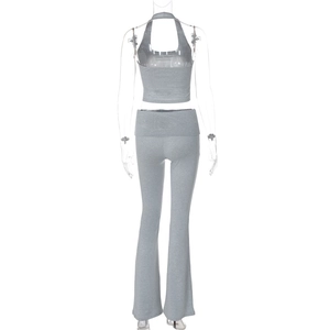 Dettaglio del top a lupetto grigio in maglia e dei pantaloni a zampa sul retro del manichino