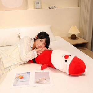 Detail of soft plush Santa Claus long cylinder body pillow in a cozy bedroom setting