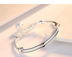 Detailed macro view of adjustable silver-plated bangle with hollow bells and beads