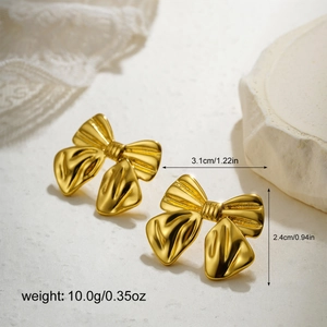 Detail shot of 18K gold bow earrings with satin-finish texture and product dimensions