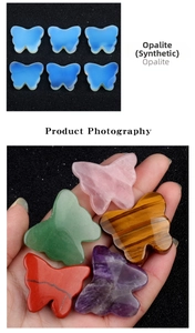 Detailed macro shot showing assorted hand-carved crystal butterfly figurines in palm