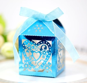 Detailed laser-cut heart pattern on metallic blue wedding favor box with ribbon bow