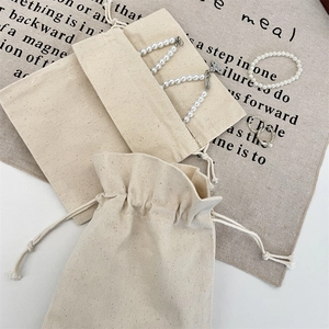 Creamy white cotton drawstring jewelry bag with natural canvas texture and woven ropes