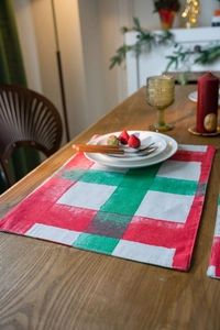 Macro detail of red and green plaid Christmas placemat on a festive wooden table