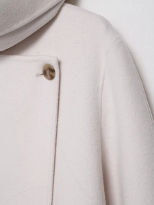 Macro shot of oatmeal wool blend coat showing fabric texture and amber marble button
