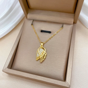Elegant gold wing pendant necklace with pavé crystals in a beige jewelry gift box