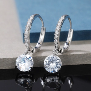 Dettaglio macro di orecchini a cerchio in argento con pendenti tondi in zircone