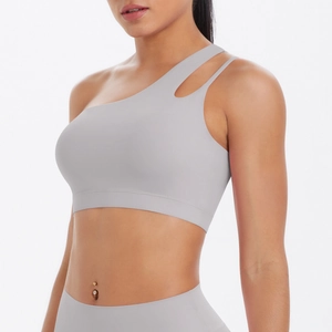 Detail of light gray asymmetrical one-shoulder sports bra with cutout strap design