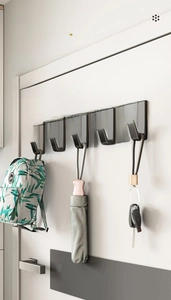 Modern black wall hooks mounted on door showing storage for bags and car keys