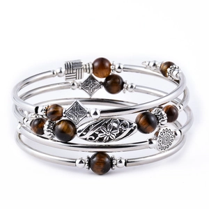 Detail of bohemian multilayer wrap bracelet with imperial jasper and vintage silver charms