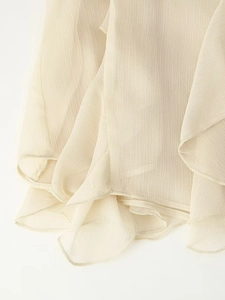 Vue détaillée de l'ourlet à volants multicouches sur une blouse en mousseline beige