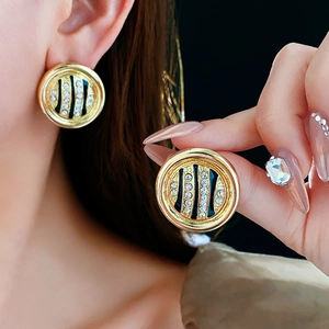 Macro shot of gold leopard print stud earrings with rhinestones on a female model