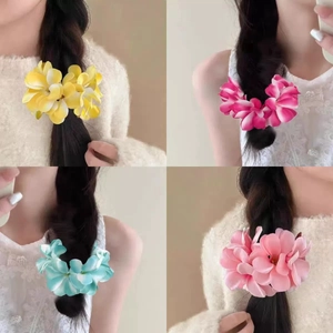 Detailed collage of floral hair clips in yellow, pink and cyan colors on model hair