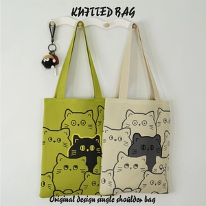 Detail of green and beige knitted shoulder bags featuring cartoon cat patterns