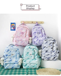 Detailed display of colorful camouflage backpacks for school with white plush bear charms