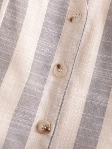 Détail de l'ensemble rayé en lin avec boutons effet marbre et texture de tissu tissé