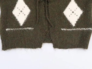 Detail of dark green knit sweater featuring white argyle pattern and drawstring tie
