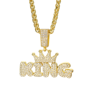 Iced out gold KING crown pendant necklace with hip hop twist chain on white background