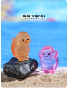Close-up of cute luminous resin turtles on beach pebbles with soft blue background