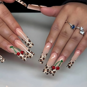 Extra long leopard french nails with 3D red cherry accents and glossy nude finish