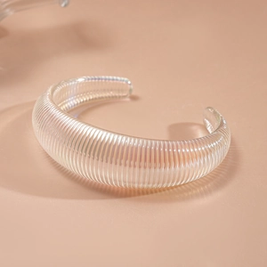 Macro view of iridescent acrylic geometric bangle with vertical ribbed texture detail