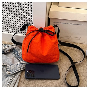 Close-up of vibrant orange drawstring bucket bag made of durable nylon material