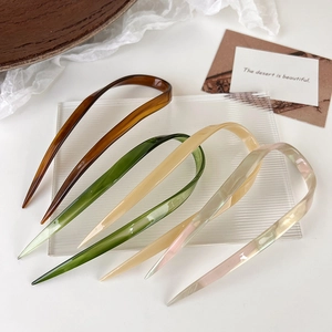 Elegant U-shaped hair pins in vintage colors on a minimalist display setting