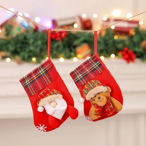 Mini Christmas stockings with Santa and bear patterns hanging on a festive mantel