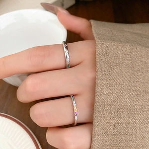 Detail of star-engraved silver ring with colored zircon on a model's hand