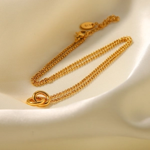 Minimalist double interlocking ring pendant necklace in gold finish on white silk