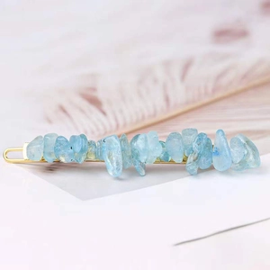 Detailed macro shot of light blue natural crystal stones on a golden metal hair pin