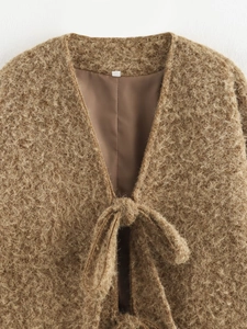 Detail of brown plush faux fur cardigan featuring stylish tie-front closure and soft texture