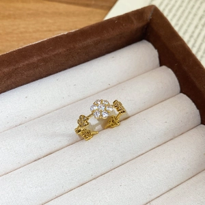 Detailed close-up of golden open ring with star-shaped zircons in a velvet box